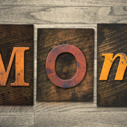 The word "MOM" written in wooden letterpress type.