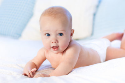 Schattige baby geboren door mini-IVF op bed | Tennessee Reproductive Medicine | Chattanooga