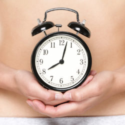 Woman holding an alarm clock representing her biological clock and diminished ovarian reserve | Tennessee Reproductive Medicine | Chattanooga, TN