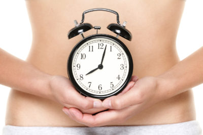 Woman holding an alarm clock representing her biological clock and diminished ovarian reserve | Tennessee Reproductive Medicine | Chattanooga, TN