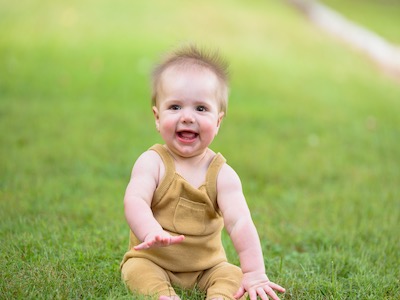 Baby boy in sitting on grass birthed with help of varicocele surgery | Tennessee Reproductive Medicine | Chattanooga, TN