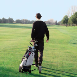 Man Walking a Golf Course with His Clubs | Tennessee Reproductive Medicine