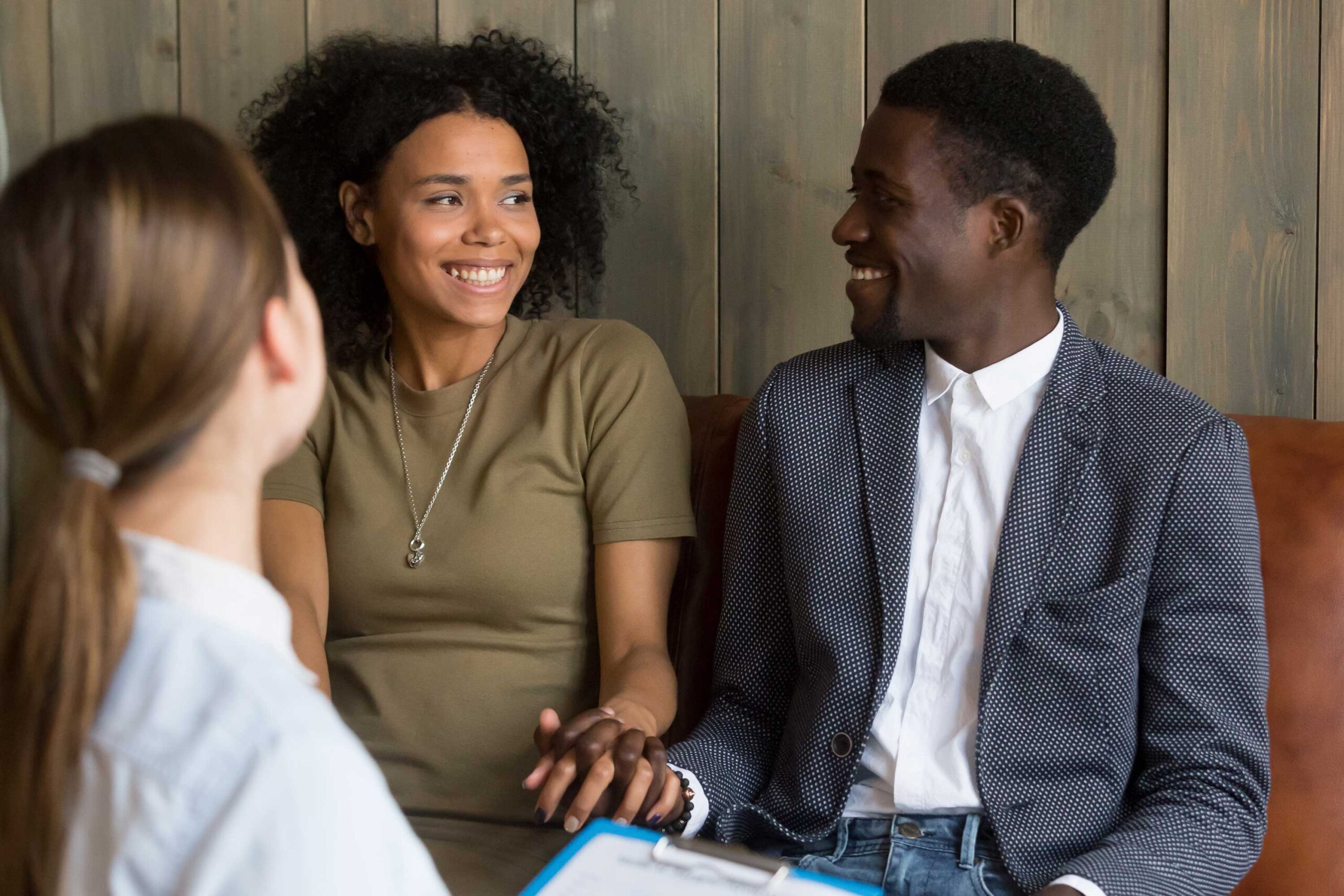Smiling Black couple discussing financing for low IVF cost treatments with counselor | Tennessee Reproductive Medicine | Chattanooga, TN