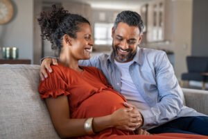Happy mid adult couple caressing mom's pregnant belly | Tennessee Reproductive Medicine 