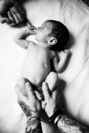 Kai, who was born through the generosity of embryo donors, holding one mom's finger while his other mother holds his feet | Tennessee Reproductive Medicine, Chattanooga, TN